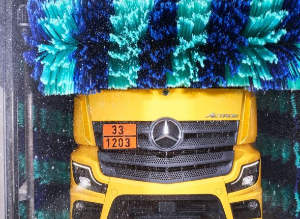 Gelber Lkw der Alois Killisperger GmbH in der Waschanlage in Wertingen, mit rotierenden Waschbürsten