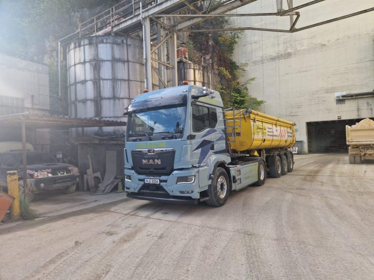 Elektro-Lkw im Kipperbetrieb: elektrische MAN-Sattelzugmaschine vor dem gelben Kipperauflieger der Alois Killisperger GmbH